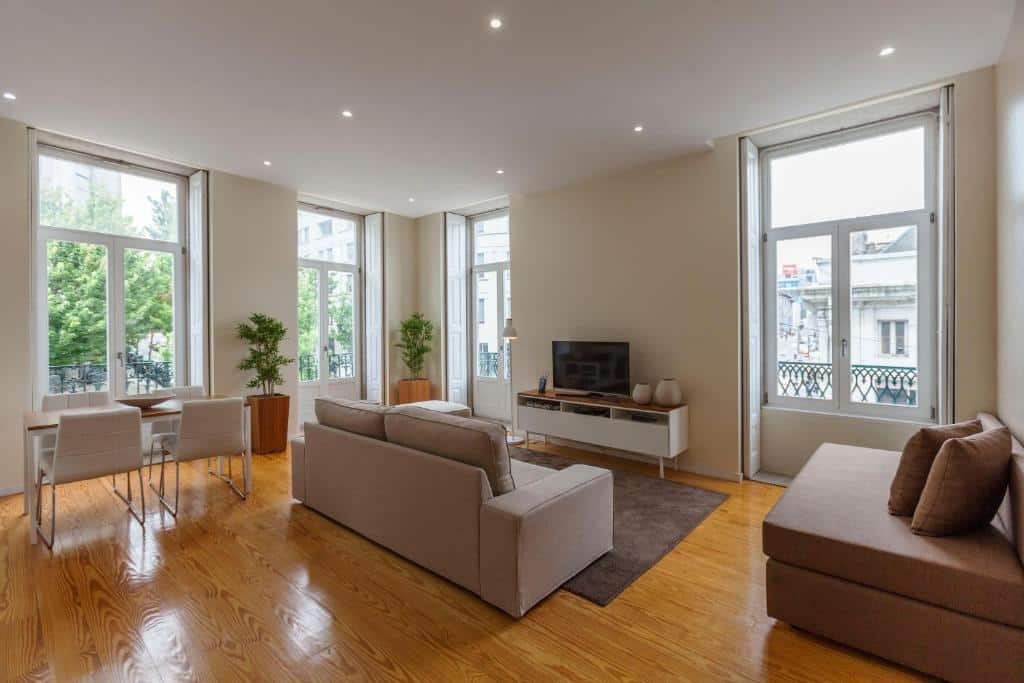 Sala de estar do BO - Fernandes Tomás Apartments com sofá do lado direito da imagem e em frente uma cômoda com TV.