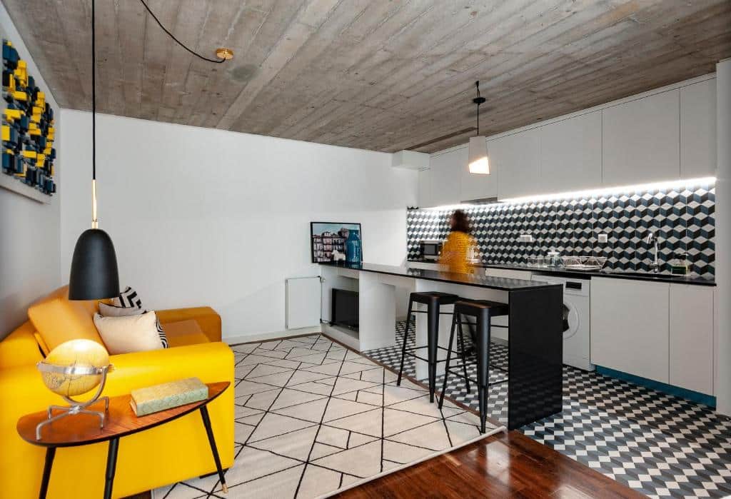 Sala do PortoSoul Trindade com sofá do lado esquerdo da imagem com um balcão a frente e ao fundo a cozinha.