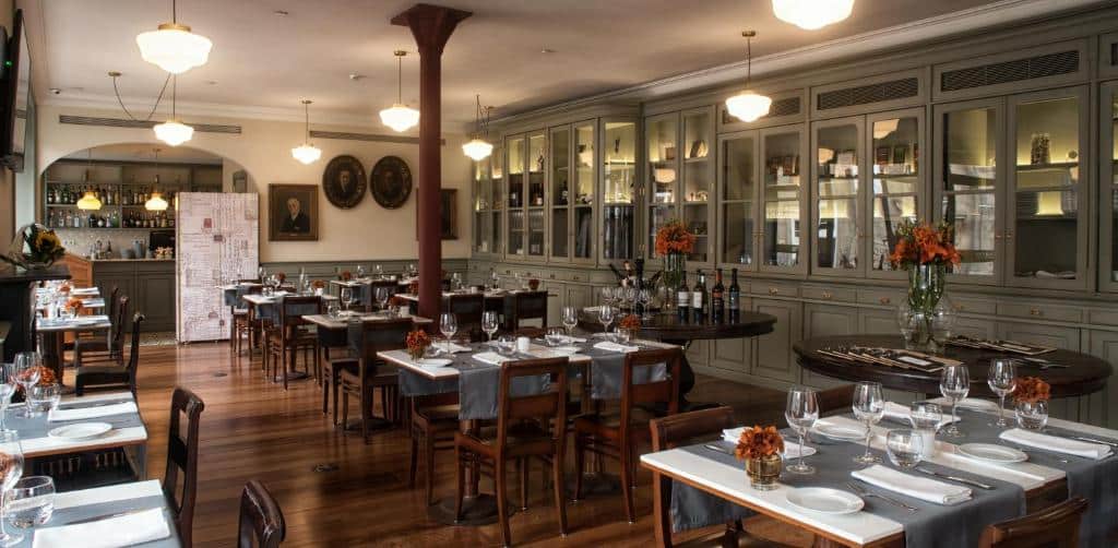 Sala de refeição do Porto A.S. 1829 Hotel com mesas e cadeiras.