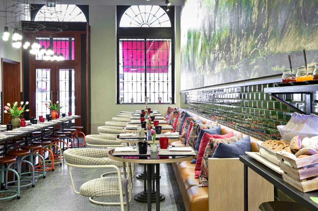 Sala de refeição do The Editory House Ribeira Porto Hotel com cadeiras e sofás no ambiente.