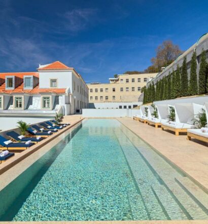 Piscina do The One Palácio da Anunciada em um terraço alto com espreguiçadeiras nos dois lados da piscina, para representar hotéis com piscina em Lisboa