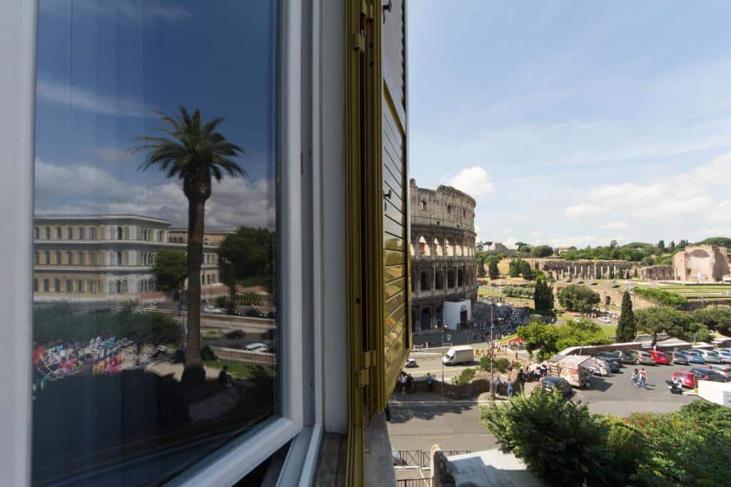 vista da janela do B&B Colosseo Panoramic Rooms em que é possível ver o Coliseu e mais a rua abaixo, muito próximo