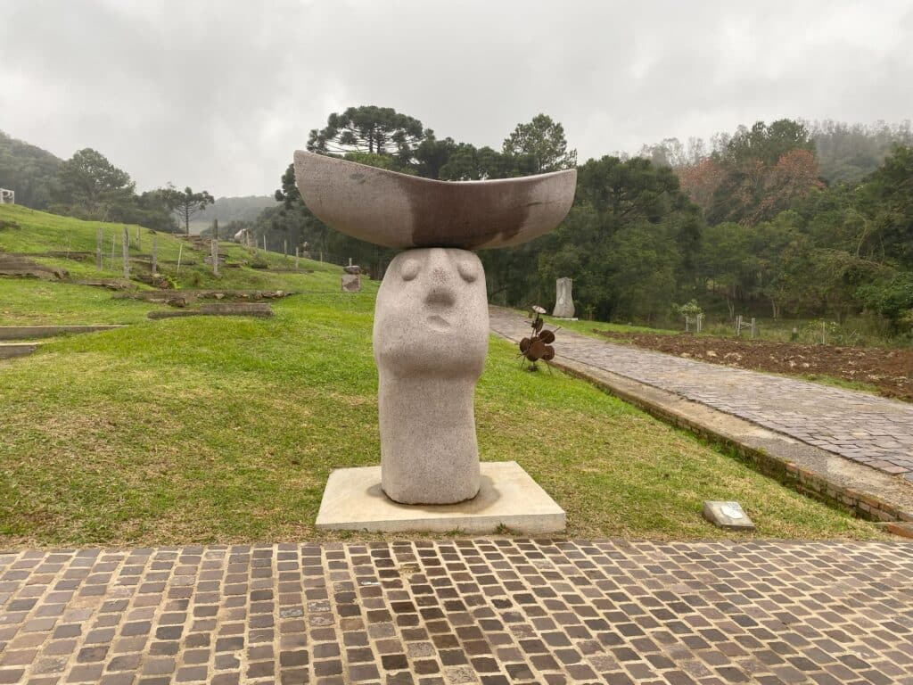 A escultura "Barco dos Sonhos", de Jerome Symons, dos Países Baixos, na qual se vê uma cabeça, esculpida em pedra, com uma forma geométrica em formato de barco, também esculpida em basalto, apoiada sobre ela