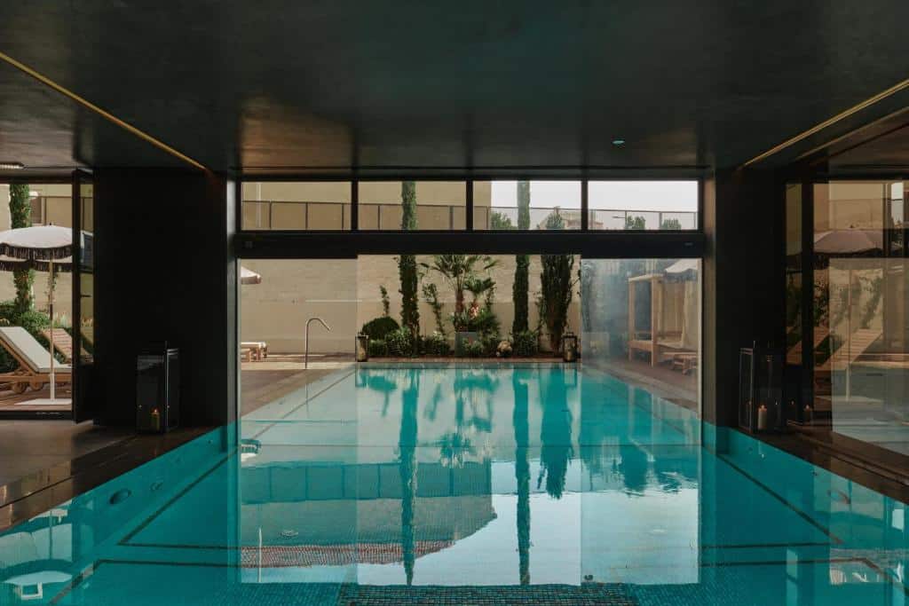 Piscina coberta do GA Palace Hotel com piscina a frente da imagem.