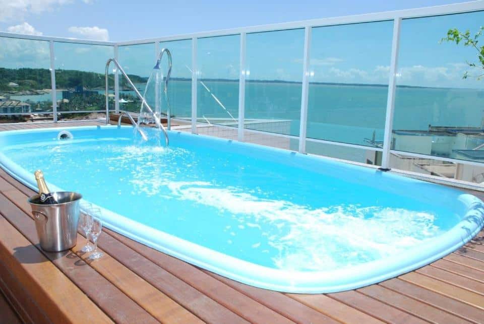 Piscina da  Pousada Barlavento. Uma piscina no terraço, com um champagne e duas taças no lado esquerdo, No lado direito e no fundo, o vidro cercando a piscina, com vista para o mar.