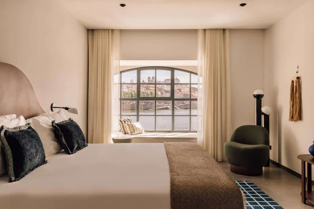 Quarto do The Rebello Hotel & Spa – Small Luxury Hotels Of The World, com cama de casal do lado esquerdo da imagem do lado esquerdo da cama uma poltrona.