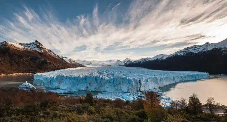 Grama na frente, atrás o lago com a Geleira Perito Moreno e montanhas ao redor. Foto para ilustrar posts sobre hotéis em El Calafate.