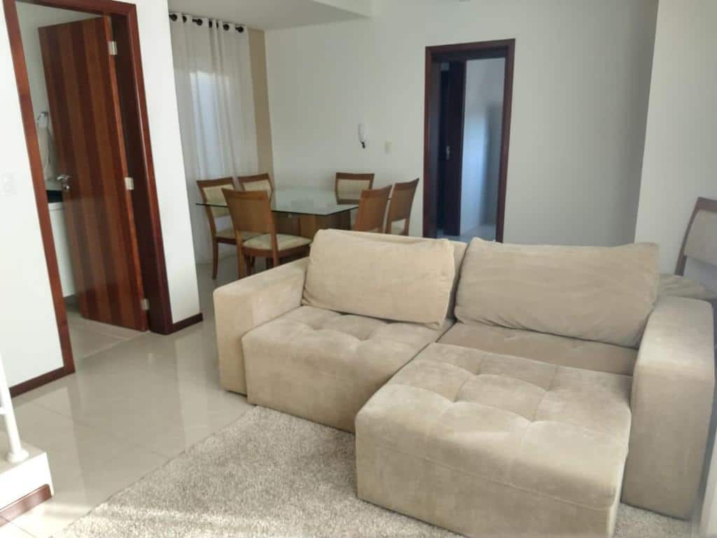 Sala de estar da Casa Curitiba 120m² (1 Suíte e 2 Quartos) junto com sala de jantar com uma mesa com seis lugares e um sofá espaçosos