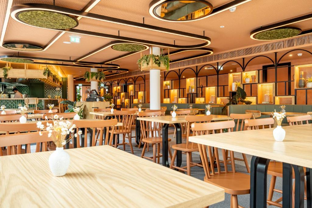 Sala de refeição do The Editory Garden Porto Hotel  com mesas e cadeiras no ambiente.
