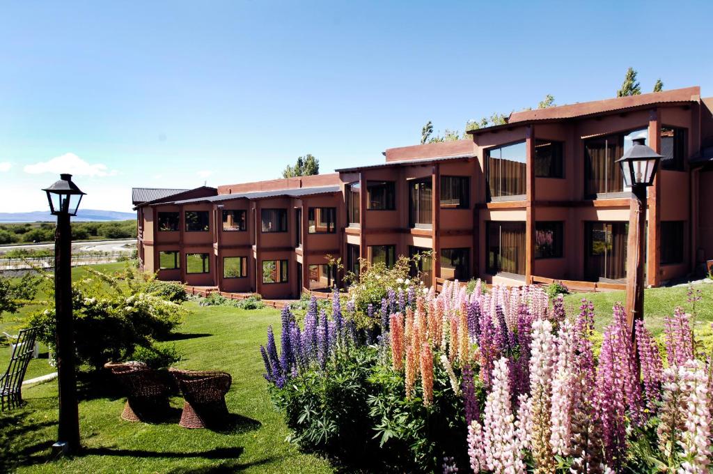 Na frente flores, banquinhos e um jardim, atrás os quartos do hotel Sierra Nevada.