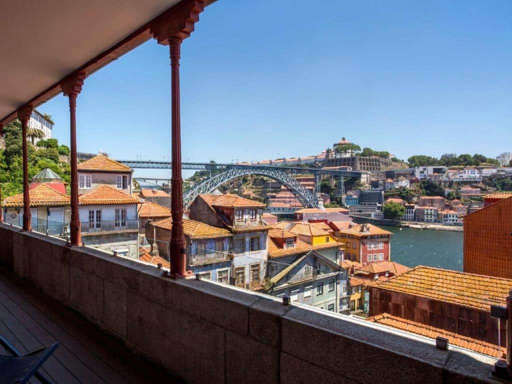 Varanda do Hotel Carris Porto Ribeira durante o dia com vista para as casas do Cais da Ribeira, ao fundo o rio Douro e a Ponte D. Luís I.