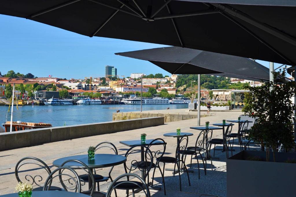 Vista da varanda térrea do Pestana Vintage Porto Hotel & World Heritage Site com cadeiras e mesas do lado direito da imagem e do lado esquerdo o rio Douro.