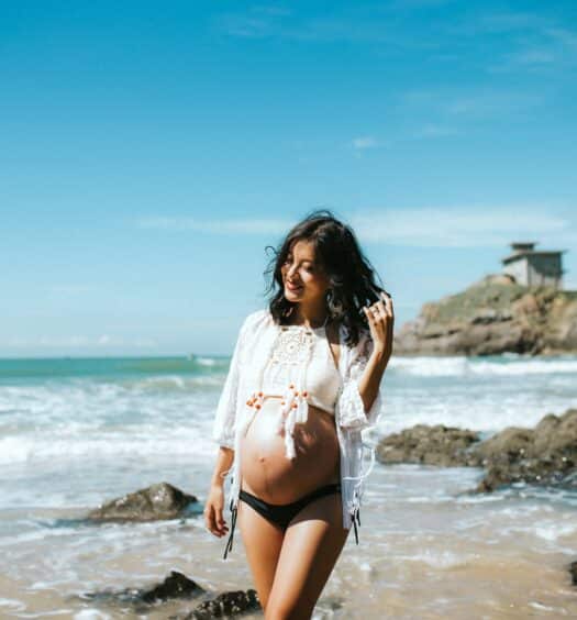 Mulher grávida na praia, ilustrando post de seguro viagem para gestante. - Foto: Anthony Tran via Unsplash