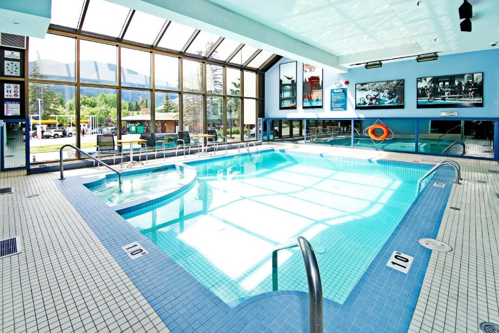 Parte do Best Western Plus Siding 29 Lodge que mostra a piscina de azulejos em um local coberto e a claridade entra pela parede de vidro a esquerda da imagem, ilustrando post Hotéis em Banff.