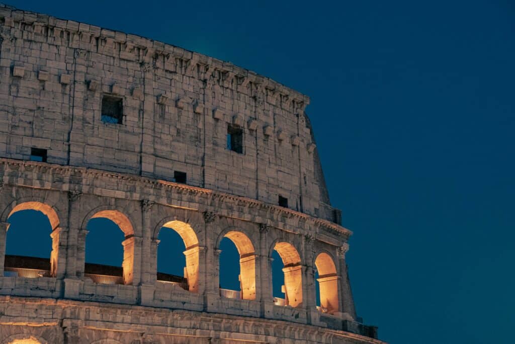Parte do Coliseu, em Roma, iluminada ao anoitecer, para ilustrar a capa do post sobre os destinos mais visitados da Europa