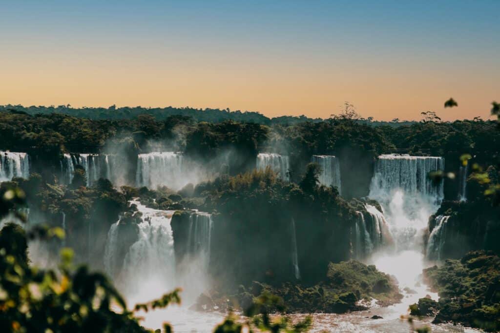 Várias quedas de água que formam cachoeiras cercadas por árvores em Foz do Iguaçu no Brasil