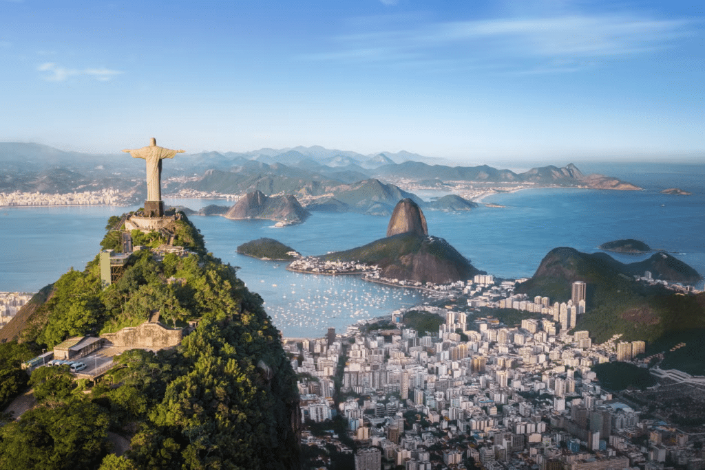 Vista incrível do Cristo Redentor e do Morro com as praias abaixo e vários prédios, no Rio de Janeiro
