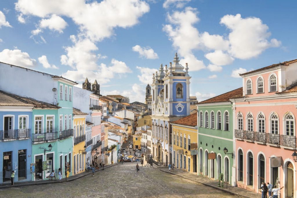 Vista da rua pelo Pelourinho, em Salvador, com casinhas coloridas ao estilo colonial com igrejas e torres imponentes