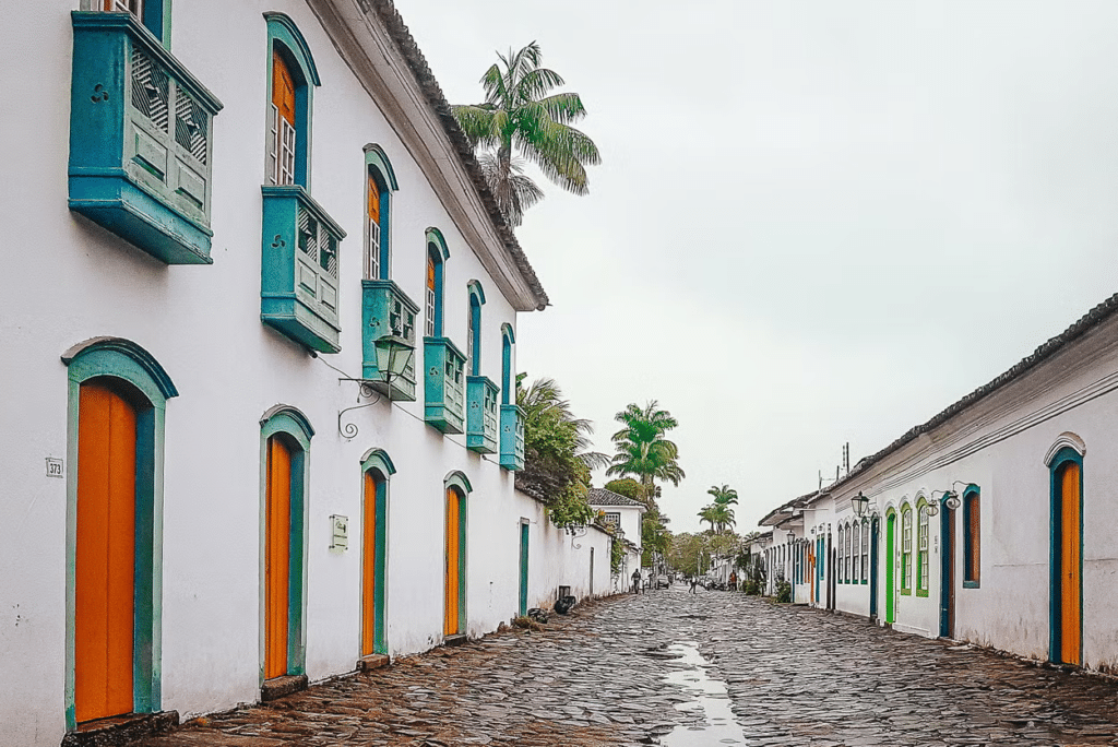 Ruas de pedra, conhecidas como pé de moleque, e casinhas ao estilo colonial com portas e janelas de madeira arredondadas, algumas com mini sacadas e bem coloridas, em Paraty
