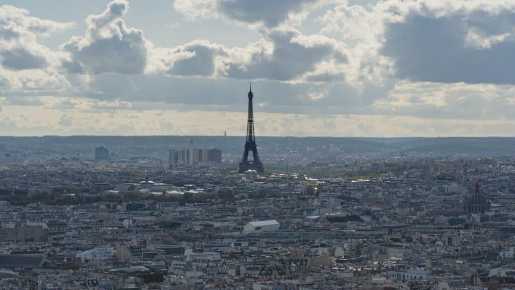 Foto aérea do horizonte de Paris, com a Torre Eiffel imponente em destaque no meio das construções da capital francesa