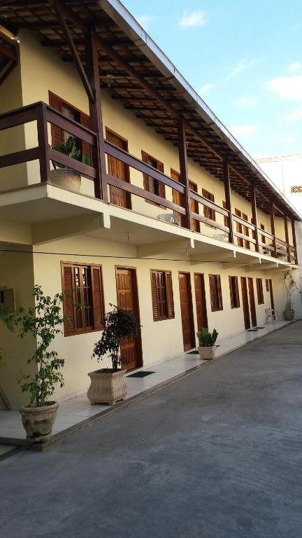 Fachada de dois andares da pousada que mostra as portas e janelas de madeira dos quartos da Pousada da Nalva durante o dia, ilustrando post Pousadas em Rio das Ostras.
