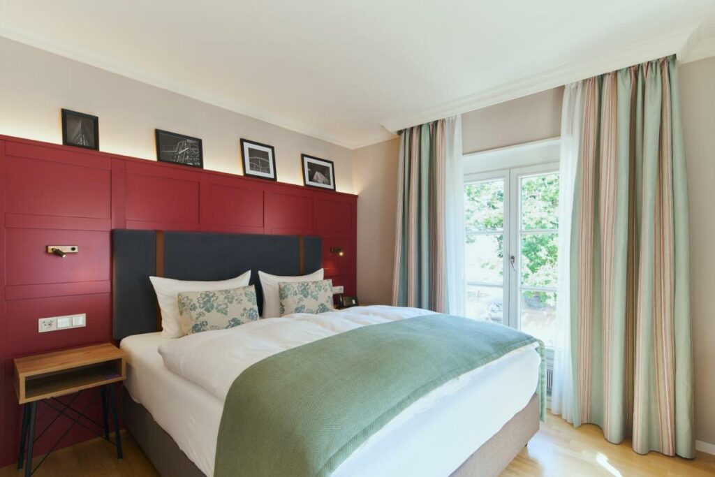 Quarto do Hotel Orangerie com cama de casal do lado esquerdo da imagem. Representa hotéis em Dusseldorf.