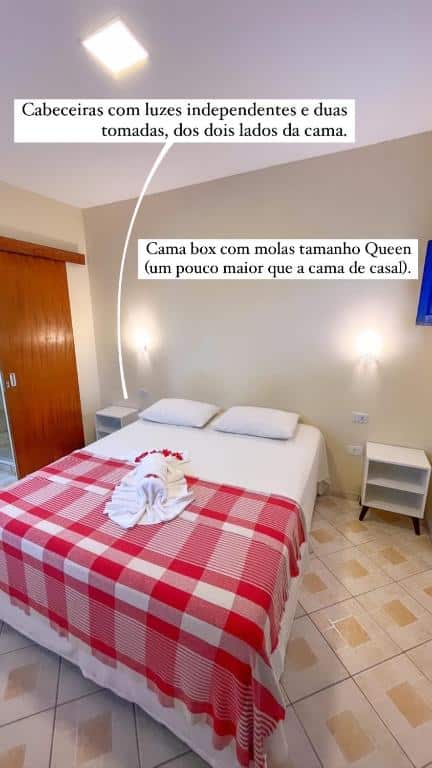 Quarto da Pousada Carpe Diem. A cama está centralizada, há duas mesinhas em cada lado da cama e é possível ver um pouco de uma porta no lado esquerdo. Imagem para ilustrar o post pousadas em Maracaípe.