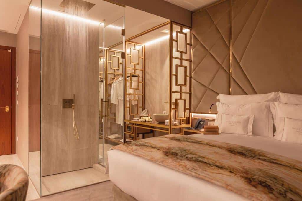Quarto do Wine & Books Lisboa Hotel com cama de casal do lado direito da imagem, do lado esquerdo uma parede espelhada. Representa hotéis para lua de mel em Portugal.