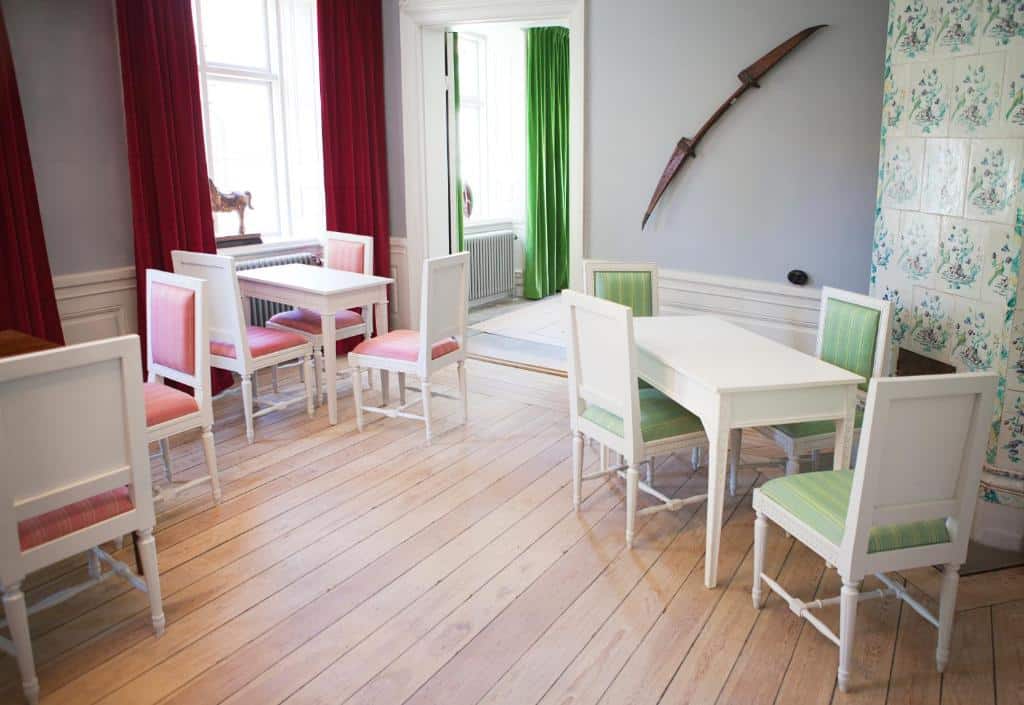 Sala de refeição do Hotel Hellstens Malmgård com mesas e cadeiras no ambiente.
