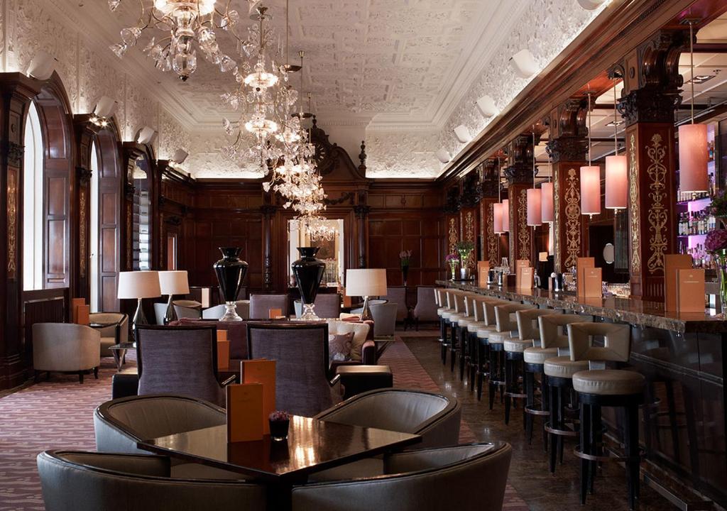 Sala de refeição do Grand Hôtel Stockholm com cadeiras e balcão do lado direito da imagem, já no centro da imagem cadeiras e mesas.
