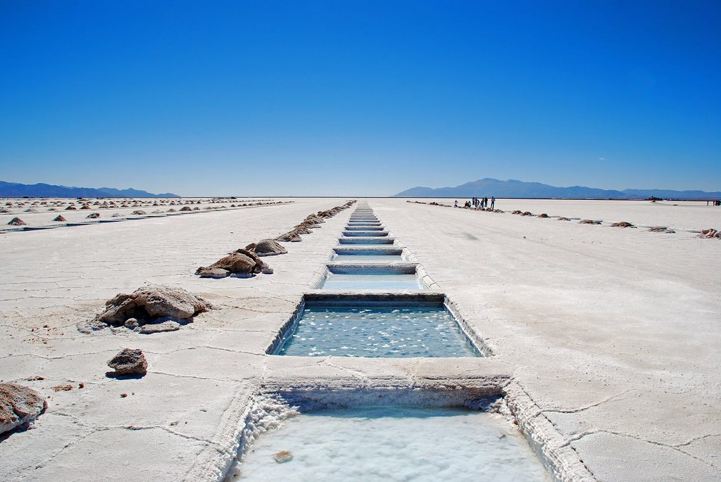 Imagem das Salinas Grandes, o deserto de sal em Jujuy. No meio, em fileira reta, vários quadrados com gelo, e ao redor o deserto de sal.