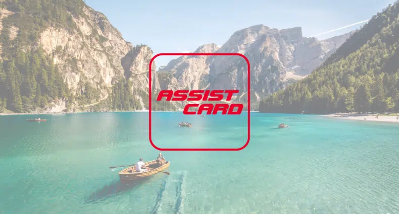 Um lago em verde claro com alguns barcos passando, ao fundo há diversas montanhas, para representar a seguradora Assist Card