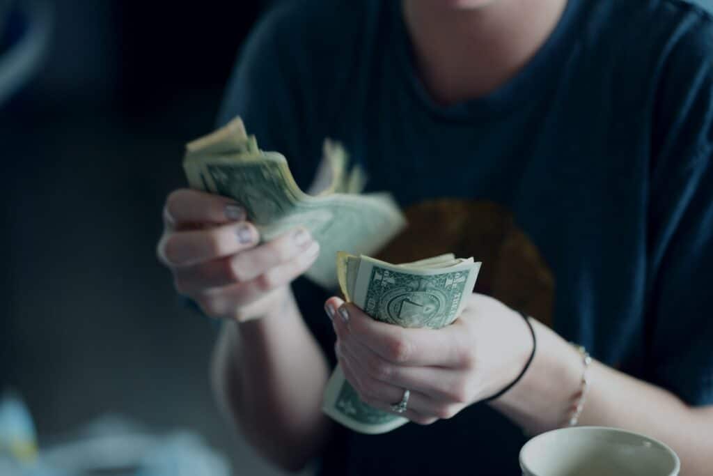 Uma mulher contando notas de dólares