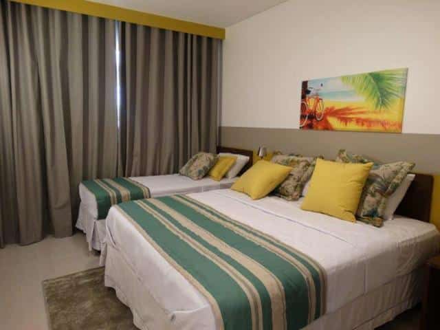 Quarto do Apartamento em Resort de Olimpia. Uma cama de casal e uma cama de solteiro do lado direito, no fundo a cortina.