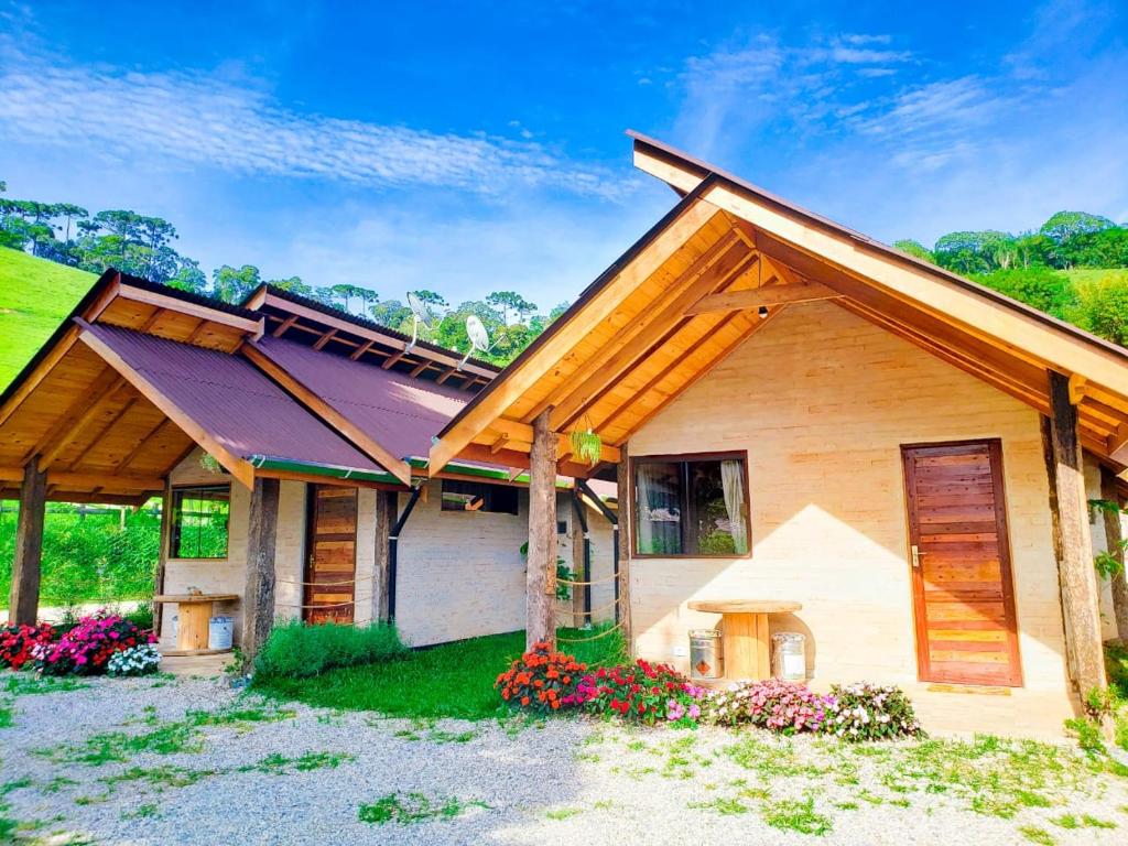 Área externa do Chalé na Montanha. Dois chalés com um jardim na frente.