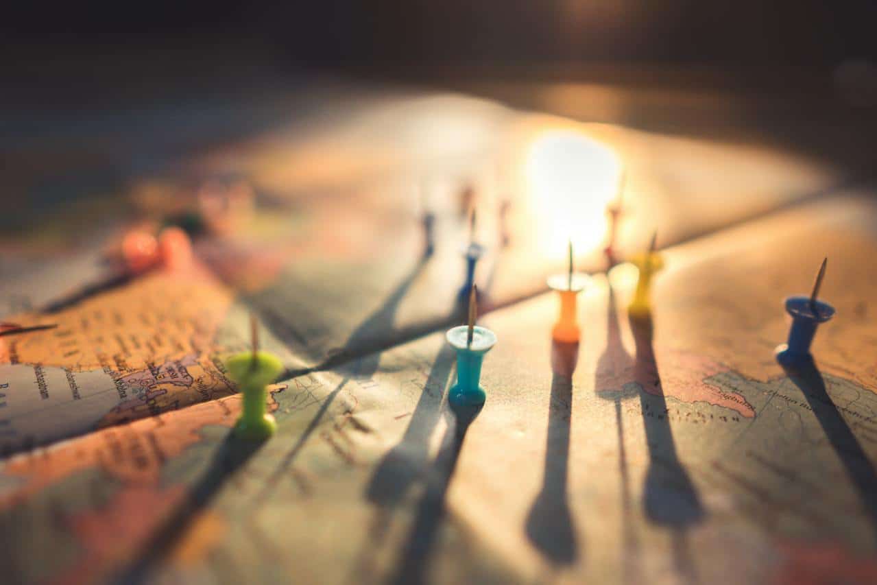 Luz do sol iluminando um mapa da Europa com alfinetes coloridos virados para cima. A imagem ilustra o post sobre Tratado de Schengen. - Foto: Aksonsat Uanthoeng via Pexels