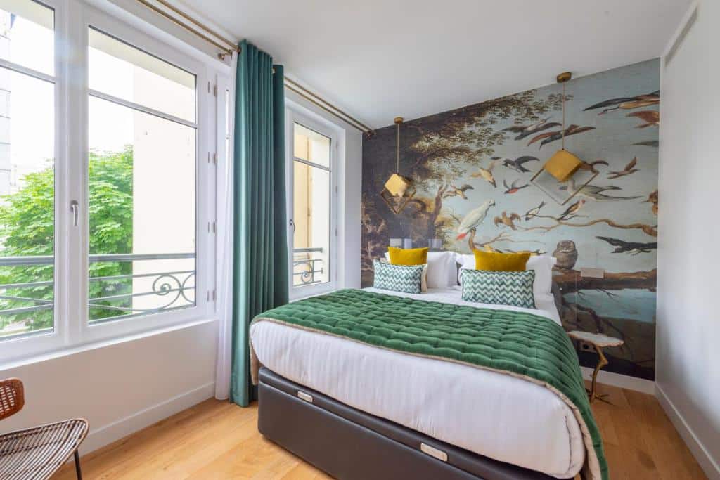 Quarto da O'Lord, 4 Etoiles, Residence de Luxe Champs-Elysees. Uma cama de casal está no centro do quarto com uma linda pintura na parede atrás da cabeceira e luminárias e mesinhas de cabeceira dos dois lados. Duas janelas com cortinas ficam na parede ao lado esquerdo.