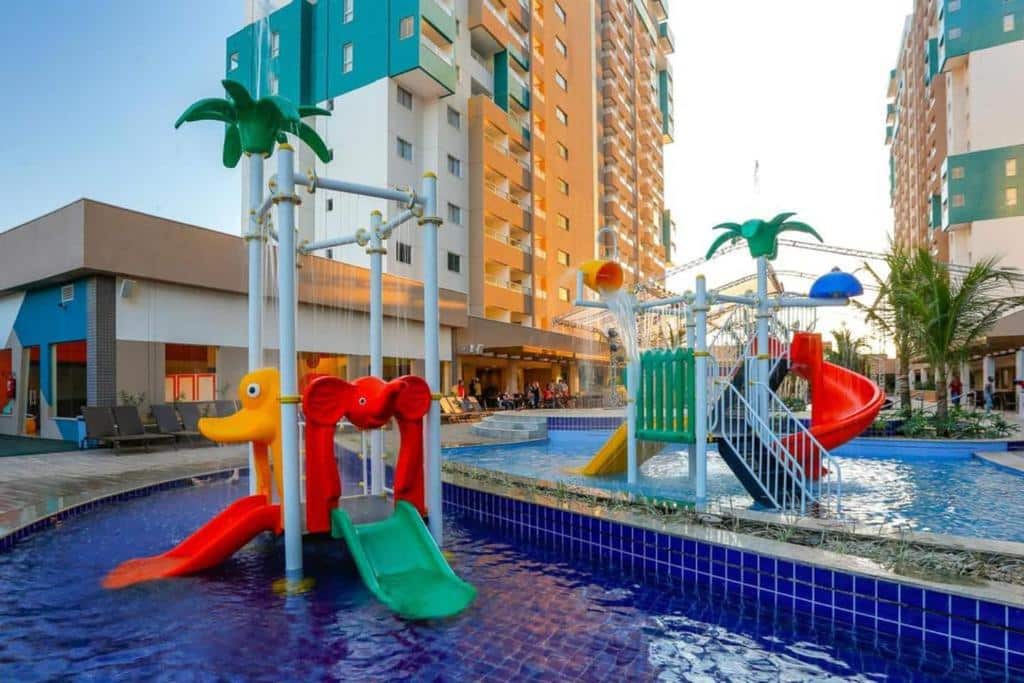 Uma das piscinas do Olímpia Park Resort. Brinquedos infantis aquáticos, no fundo os prédios.