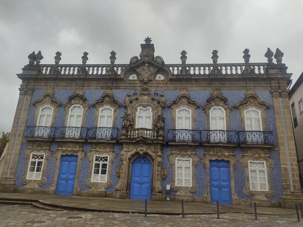 Vista durante o dia do Palácio do Raio com azulejos em sua faixadas e portas azuis.