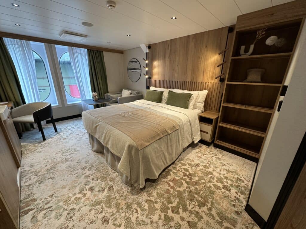 Cabine com cama de casal, mesas de cabeceira, estantes e carpete no SH Vega, um dos navios da Swan Hellenic