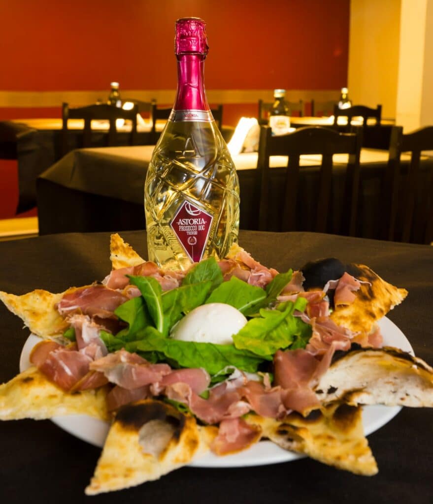 Imagem do prato Tagliere Villa Itália, do restaurante Villa Itália. No fundo uma garrafa de bebida.