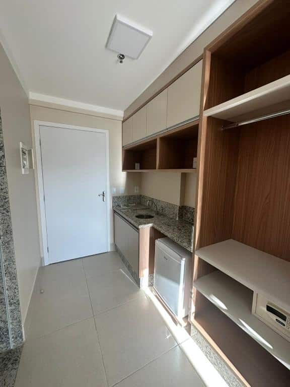 Mini cozinha do Spazzio DiRoma / Acqua park. Do lado direito um armário com cofre, frigobar e pia. No fundo a porta do quarto.