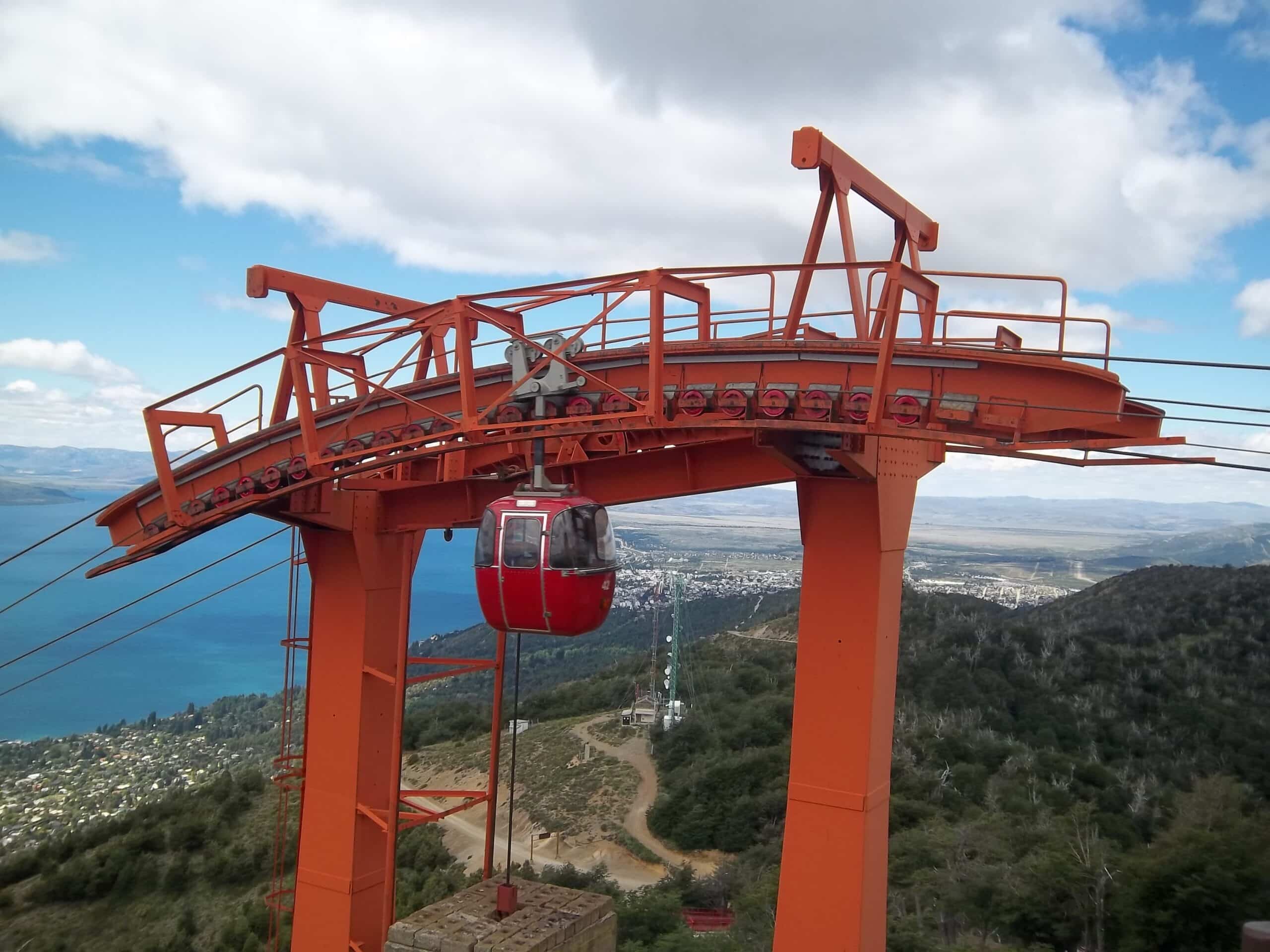 A cabine do teleférico do Cerro Otto no meio, com vista para árvores, cidade e o lago. Imagem para ilustrar post sobre o que fazer em Bariloche.