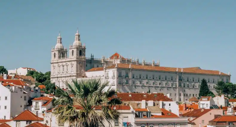 vista do bairro de Alfana, em Lisboa, Portugal, com várias casinhas e uma igreja grande em tons claros e telhados marrons