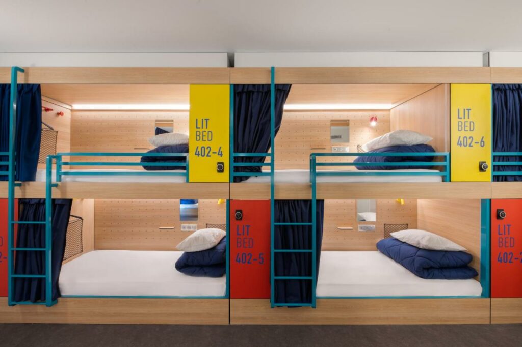 Quarto do Auberge de jeunesse Hosho Paris Sud - Porte d'Italie com quatro camas em beliche que possuem travesseiro, cobertor, luz e cortina de privacidade.