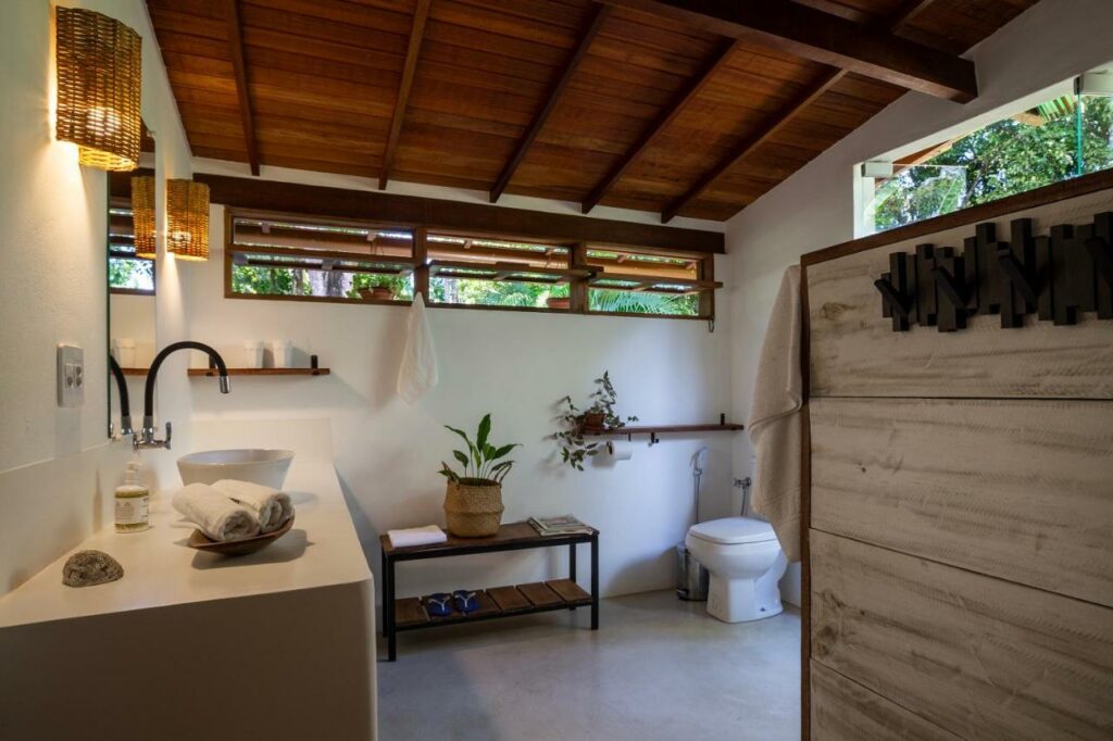 Banheiro com baixa mobilidade da Casa Acácias com pia baixa do lado esquerdo da imagem e do lado direito vaso sanitário.