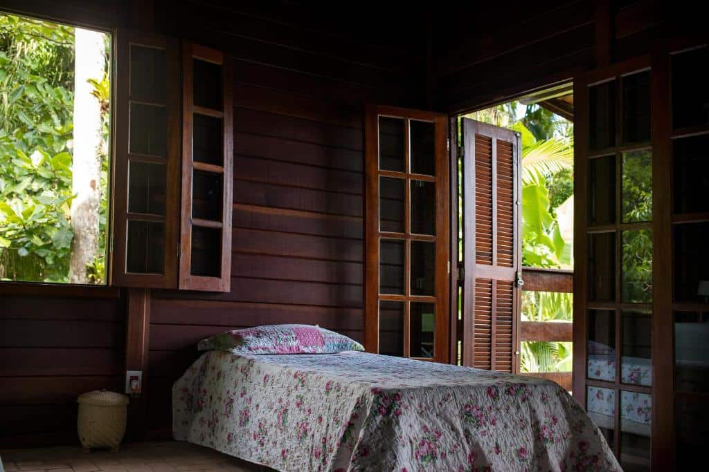 Quarto da Casa da Justa. Uma cama de solteiro no meio, do lado direito uma porta e do lado esquerdo uma janela. Foto para ilustrar post sobre airbnb em Ubatumirim.