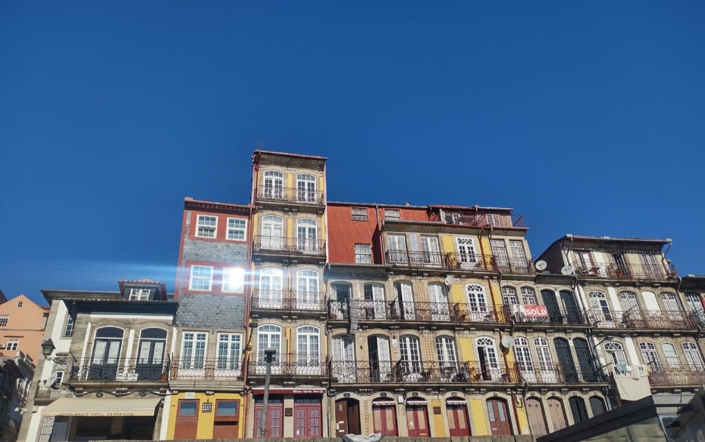 Casinhas coloridas no Cais da Ribeira durante o dia. Representa o que fazer no Porto.