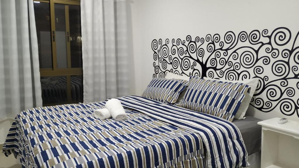 Quarto do Concept Tower Praia Apart. Uma cama de casal no meio, com toalhas. No fundo a janela grande do quarto. Foto para ilustrar post sobre airbnb em Aracaju.