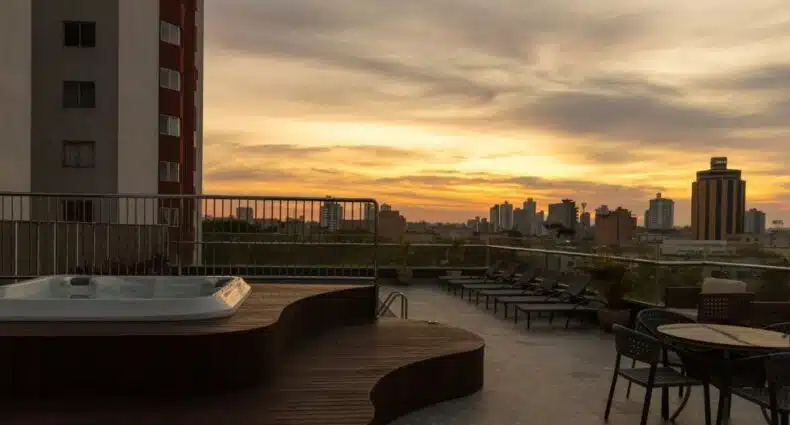 Imagem do Del Rey Quality Hotel que mostra do lado esquerdo uma banheira de hidromassagem com vista para os prédios ao pôr do sol. Imagem ilustrando post Hotéis em Foz do Iguaçu.